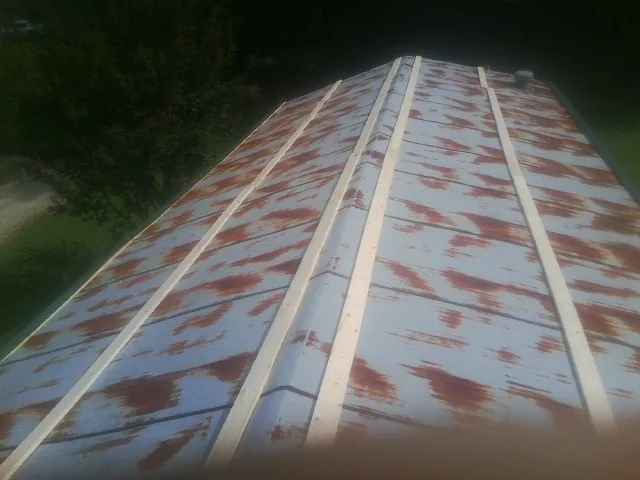 Rusted metal roof panels with new wood purlins before replacement — Storm Damage Roof Repair in Jenison by Roofing Brothers