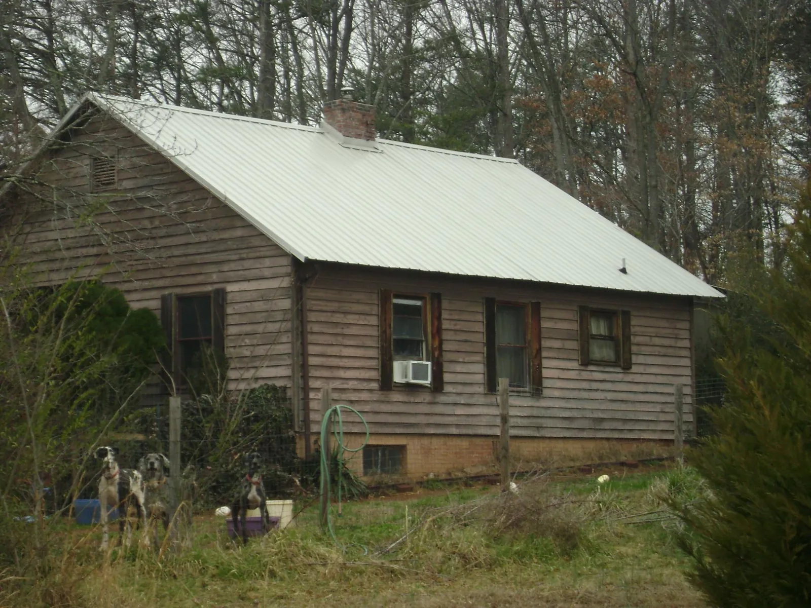 White metal roof on an old wood sided farmhouse, from a Metal Roof Installation job in Jenison